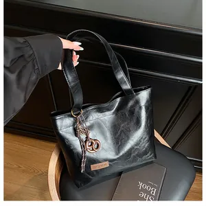Gros plan du sac cabas noir avec étiquette de mode marron et cordon de serrage noué