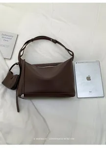 Detailed view of large brown lychee leather tote bag with a small hanging coin purse
