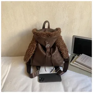 Detail of dark brown faux leather and plush fur patchwork on a retro drawstring backpack