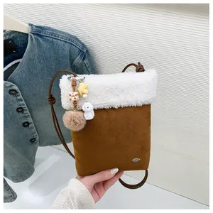 Détail d'un sac en daim marron avec bordure en peluche blanche et breloque étoile
