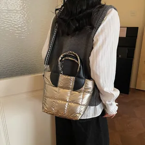 Borsa a secchiello trapuntata oro metallizzato con tracolla geometrica su una modella