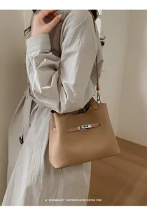 Detail view of camel bucket bag with lychee grain texture and silver twist lock closure