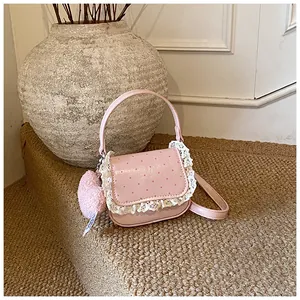 Sac à main rose à pois rouges avec dentelle et porte-clés cœur en peluche sur tapis