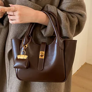 Retro dark brown leather handbag with gold twist lock and mini bag charm for women