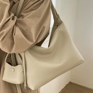 Minimalist beige pebble leather tote bag with matching mini pouch charm for daily commute