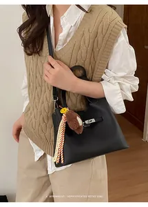 Classic black pebbled leather bucket bag styled with a scarf and cute bear charm