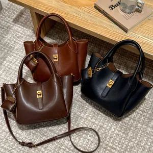 Minimalist retro leather crossbody bags in brown and black with gold buckle hardware