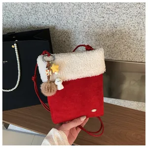 Vue détaillée du sac botte de Noël rouge festif avec bordure en peluche et breloques