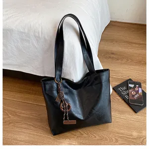 Gros plan du cabas en cuir PU noir avec étiquette tendance et texture en cuir grainé fin