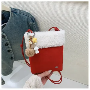 Détail du sac à bandoulière festif rouge avec rabat en sherpa blanc et breloques en peluche
