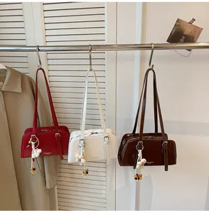 Close-up of three elegant tote bags in red, white and brown with floral bag charms