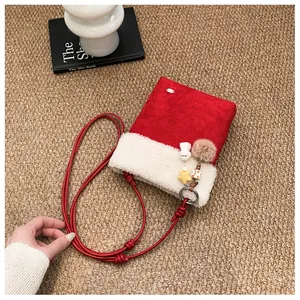 Détail du sac patchwork en daim rouge et sherpa blanc avec des breloques peluche