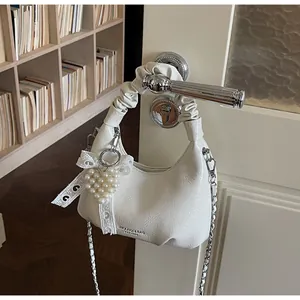 Detail of white crescent mini bag with ruched handle and pearl heart lace charm