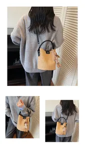 Detail of camel suede bucket bag with DM logo and cute brown rabbit plush charm