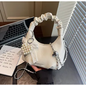 Detail of white PU leather bag with ruffled handle, pearl heart charm and metal chain