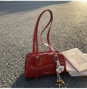 Detail of red patent leather tote bag with silver hardware and floral charm pendant