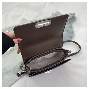 Internal structure of brown leather crossbody bag with silver buckle and zipper pocket