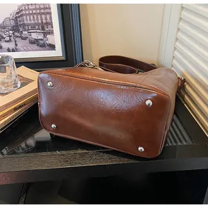 Detail der braunen Wachsleder-Tasche mit silbernen Schutznieten am Taschenboden