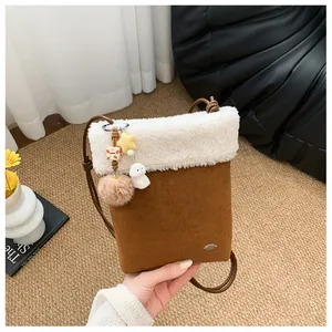 Détail du petit sac bandoulière avec textures en peau lainée blanche et daim marron