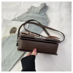 Close-up of deep brown crossbody bag with silver twist lock and printed silk scarf detail