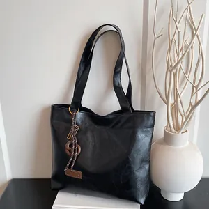 Sac fourre-tout noir minimaliste avec pendentif mode et similicuir texturé pour le quotidien