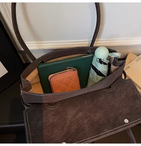 Top view of a brown tote bag interior with a tablet, wallet, and umbrella for storage