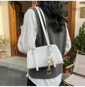 Detail of white PU leather tote bag with knit flower and wood bead charm on shoulder