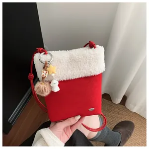 Détail d'un sac bandoulière festif en peluche rouge et blanc avec pendentif étoile