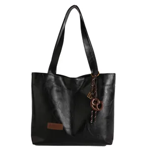 Sac fourre-tout minimaliste en cuir noir brillant pour femme avec charm bretzel chic