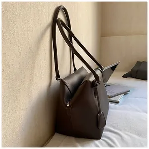 Détail du sac cabas en cuir marron foncé avec fermeture éclair latérale et texture grainée