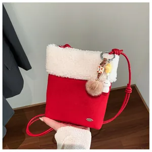 Détail du sac à bandoulière d'hiver rouge en daim avec bordure en peluche blanche