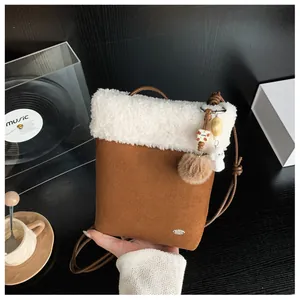 Détail du sac d'hiver en daim marron avec texture en fausse fourrure blanche douce