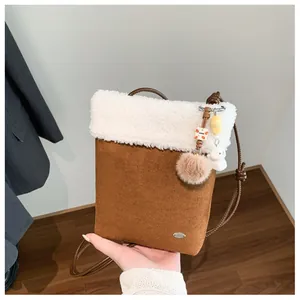 Détail de la bordure en fausse fourrure et texture suédine marron du mini sac bandoulière