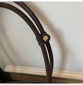 Detailed view of dark brown pebbled leather handles with silver metal snap fastener