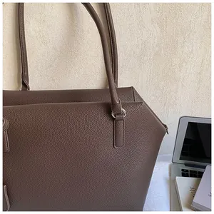 Détail d'un sac à bandoulière en cuir grainé avec anneau métallique argenté poli