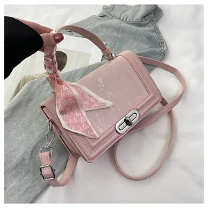 Detail of pink crossbody bag with heart-print silk scarf wrapped around handle