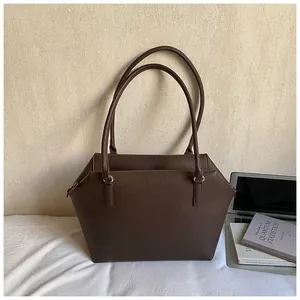 Détail du sac cabas marron foncé à grain de litchi avec anneau argenté et fines anses