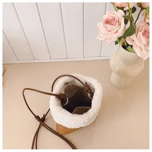 Détail intérieur du sac seau en peluche et suédine avec bandoulière et poche ouverte