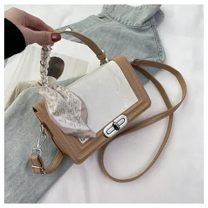Close-up of contrast crossbody bag with textured panel and silk scarf wrapped handle