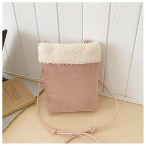 Détail du sac bandoulière en suédine rose avec bordure en peluche blanche et plaque métal