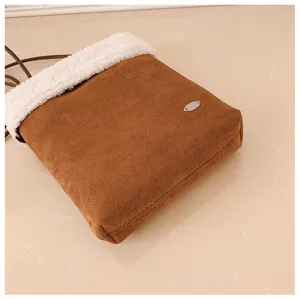 Détail de sac bandoulière d'hiver en daim marron avec bordure en peluche blanche