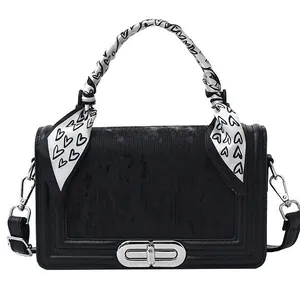 Elegant black crossbody bag with silver lock and heart print scarf on handle
