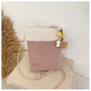 Détail du sac à bandoulière rose en daim avec bordure pelucheuse et breloque étoile