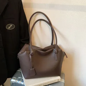 Sac fourre-tout marron café à motif litchi avec doubles anses sur un bagage