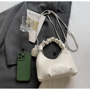 Detail of off-white ruched bag with silver chain, pearl charm and printed brand logo