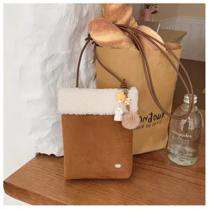Détail du sac bandoulière en daim avec bordure en peluche et pendentif étoile
