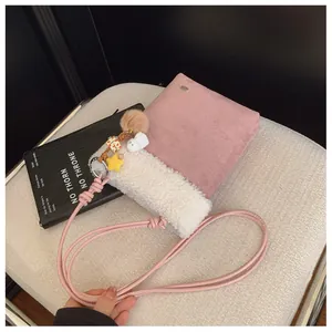 Détail du sac à main rose en daim et fausse fourrure blanche avec breloques mignonnes