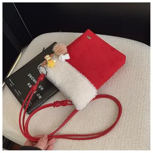 Détail du sac bandoulière rouge avec bordure sherpa et breloques étoiles en peluche