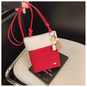 Détail du sac bandoulière rouge de Noël en peluche avec breloques étoile et chiot