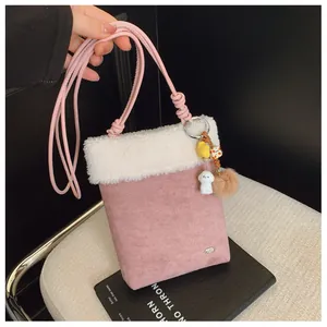 Détail du sac bandoulière rose en daim avec bordure en peluche et jolis charmes
